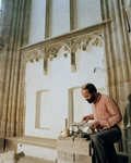 119804 Afbeelding van een steenhouwer van Aannemingsbedrijf H.J. Jurriëns B.V. aan het werk in de Domkerk te Utrecht.
